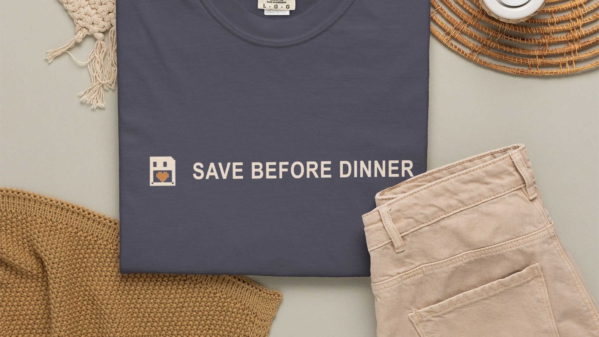 SAVE BEFORE DINNER — Comfort Colors 1717 heavyweight navy tee with pixel-art save-point print, styled flat-lay on warm taupe